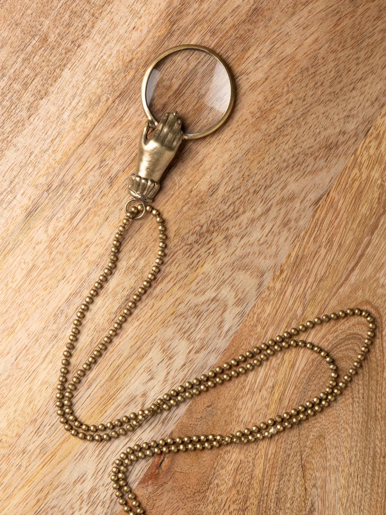 Small hand holding magnifier