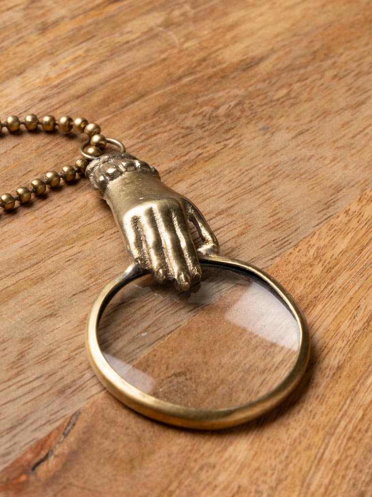 Small hand holding magnifier